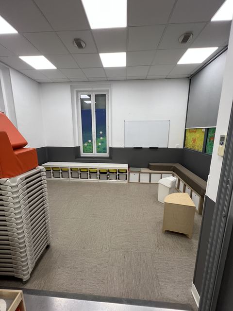 Salle de creche repeinte avec mobilier en bois et rangements colores